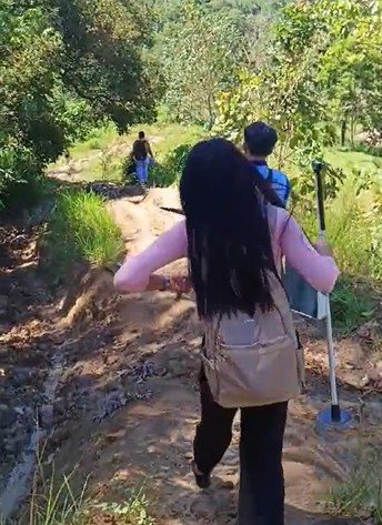 An Exakt Medical team member walking a dirt trail to reach a remote barangay