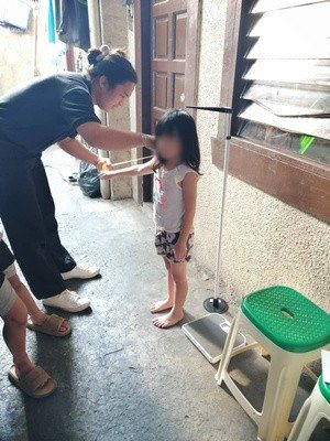 Measuring a child's height during a house-to-house visit