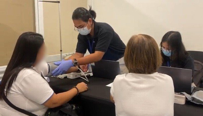 Staff recording vitals at a registration desk