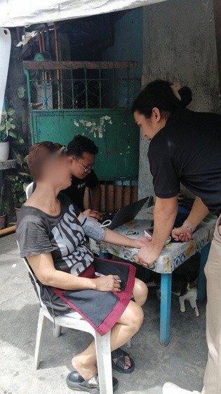 Taking a resident's blood pressure outside her home